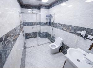 a bathroom with a shower and a toilet and a sink at RS Baku Hotel in Baku +41 photos