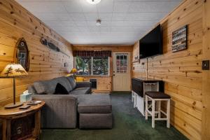 a living room with a couch and a flat screen tv at Cozy Lakeside Cabin-Lake Almanor-BoatRamp-Pets-Fun in Westwood