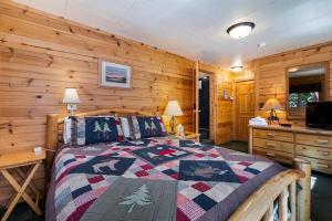 a bedroom with a bed and a wooden wall at Cozy Lakeside Cabin-Lake Almanor-BoatRamp-Pets-Fun in Westwood