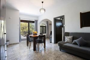 una sala de estar con una mesa y un sofá en Pelekanos Beachfront Apartment, en episkopi-chania