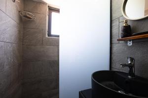 y baño con lavabo negro y ducha. en Pelekanos Beachfront Apartment, en episkopi-chania 14 fotos más