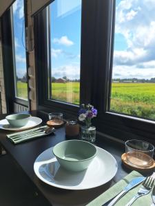 a table with bowls and plates on it with a view of a field at Villa Sees , Hailuoto 