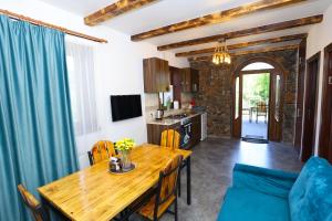 a kitchen and dining room with a wooden table and chairs at River Home in Kʼaghsi