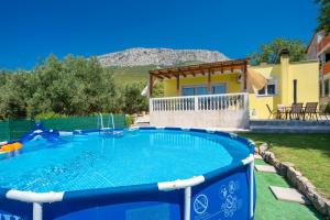 a swimming pool in front of a house at Holiday home Paligan in Solin