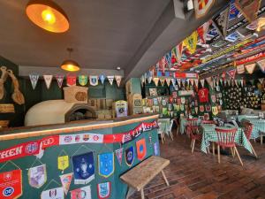 ein Restaurant mit Tischen und Stühlen und Fahnen an der Wand in der Unterkunft Albert Hotel in Roşu