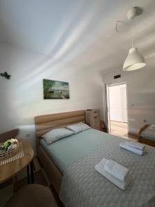 a bedroom with a bed with two towels on it at Vila Vavilon in Star Dojran