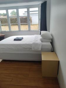 オークランドにある3 Bedroom House Aの大きな窓のある部屋のベッド