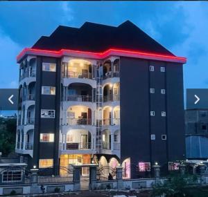 um grande edifício preto com um telhado vermelho em Azure Villa Suites Apart Hotel em Limbe