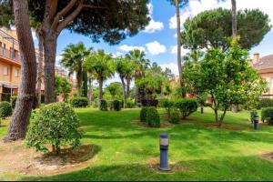 a park with palm trees and a pole in the grass at APARTAMENTO NUEVO URB ALTAVISTA VISTA CAMPO GOLF Aire Acondicionado y Wifi in Islantilla