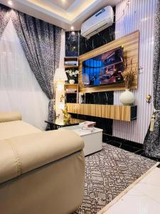 um quarto com uma cama e uma TV na parede em Azure Villa Suites Apart Hotel em Limbe