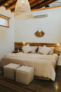 1 dormitorio con 1 cama grande y paredes blancas en Idilio Beach Apartments, en Montañita