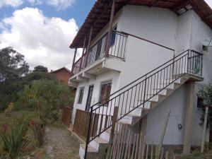 a white house with balconies on the side of it at Casa em Lavras Novas - 2 Suítes casal - AP02 in Ouro Preto