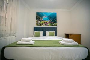 a bedroom with a large bed with two towels on it at Downtown Bayrak Residences Trabzon in Trabzon