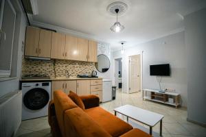 a living room with a couch and a kitchen at Downtown Bayrak Residences Trabzon in Trabzon