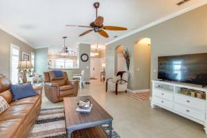 a living room with a couch and a flat screen tv at 5 Mi to Fort Myers Beach Home with Heated Pool! in Fort Myers