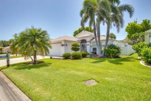 a house with palm trees in a yard at 5 Mi to Fort Myers Beach Home with Heated Pool! in Fort Myers