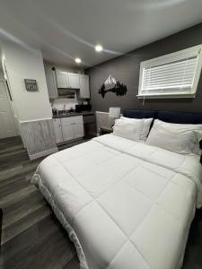 a bedroom with a large white bed and a kitchen at #10 Lakeside Great Location Beach Access Dogs ok in Kings Beach