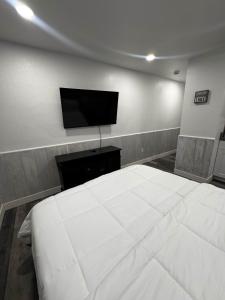 a bedroom with a large white bed and a flat screen tv at #10 Lakeside Great Location Beach Access Dogs ok in Kings Beach