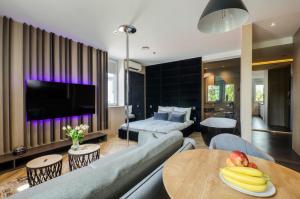 una sala de estar con un sofá y una mesa en LupoApartments z Klimatyzacją do wyboru z Jacuzzi Pole Dance Parking Dostęp na Kod, en Łódź