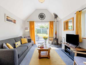 een woonkamer met een bank en een tv bij 2 Bed in Bude 82163 in Bude