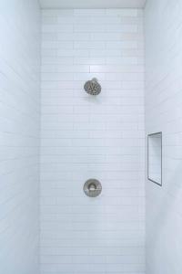 a shower with a drain in a white tile wall at Newly built vacation home with large backyard in Diamond Bar +24 photos