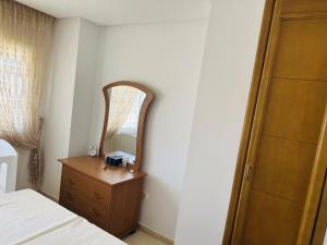 a bedroom with a bed and a dresser and a mirror at VACANCE a MAHDIA in Bin Rhilouf