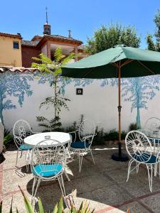 ein Tisch und Stühle mit einem Sonnenschirm auf einer Terrasse in der Unterkunft Casa Alba in Alcalá de Henares