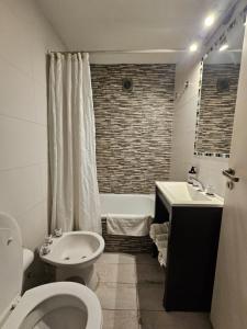 un bagno con un water, un lavandino e una vasca di Departamento Santa Fe a Salta