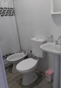 Un baño blanco con inodoro y lavabo. en Casitas de Ale en Sierra Ventana, en Sierra de la Ventana 13 fotos más