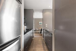 ein Flur, der zu einer Küche mit Edelstahlschränken führt in der Unterkunft At Home on Hallenstein, entire 3 bedroom townhouse in Queenstown + 24 Fotos