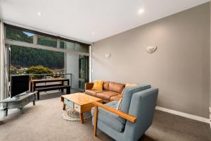 ein Wohnzimmer mit Sofa und Tisch in der Unterkunft At Home on Hallenstein, entire 3 bedroom townhouse in Queenstown