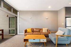 ein Wohnzimmer mit Sofa und Tisch in der Unterkunft At Home on Hallenstein, entire 3 bedroom townhouse in Queenstown