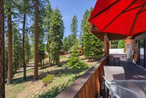 un ponte esterno con un ombrellone rosso e alberi di Wooded Escape in Tahoe Vista Private Hot Tub a Tahoe Vista