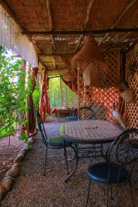 eine Terrasse mit einem Tisch und Stühlen in einem Haus in der Unterkunft Magnifica Casa cerca de Marrakech con gran piscina totalmente privada in Tahannaout
