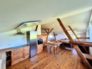 a large kitchen with wooden floors and a table with chairs at Pugholz Suite in Hasselberg
