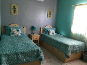 une chambre avec deux lits et une fenêtre dans l'établissement casa SUSY, à San Felipe