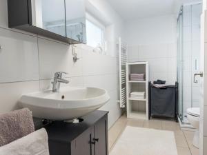 un bagno bianco con lavandino e WC di Strandwind a Oldenburg in Holstein
