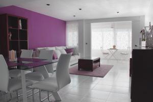Sweet Caroline Apartment في فالنسيا: غرفة طعام بجدران أرجوانية وطاولة وكراسي