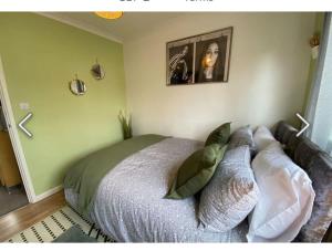 a bedroom with a bed with pillows on it at Flamingo Short Lets Greenleys in Wolverton