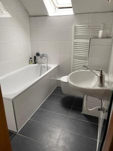 a white bathroom with a tub and a sink at Monteurwohnung Apartment mit Stellplatz in Essen