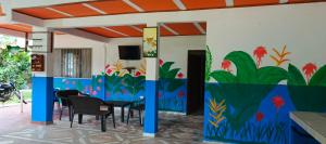 a dining room with a painting on the wall at Finca MI FUNDO in Acacías