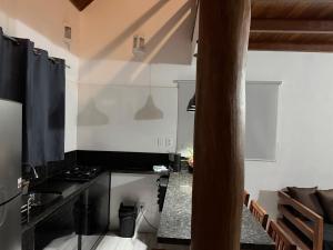 a kitchen with white walls and a black stove at Casa.dovale3 in Caeté-Açu