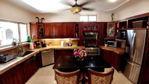 una cucina con armadi in legno e un tavolo con fiori di Beach 5 min walk - Private Casa Shona 5 Bedroom a San José del Cabo