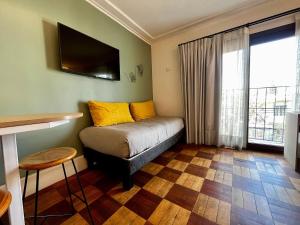 une chambre avec un lit avec des oreillers jaunes et une fenêtre dans l'établissement Living Vaisse, à Santiago