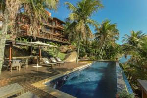 a resort with a swimming pool and palm trees at Villa Bermahe in Ilhabela