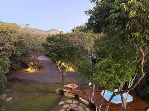 a garden with a bench next to a river at Casa.dovale3 in Caeté-Açu