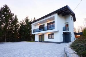 a white house with a driveway in front of it at Family friendly house with a swimming pool Karlovac - 22371 in Karlovac