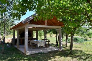 a wooden pavilion with a table in the shade at Holiday house with a parking space Saborsko, Plitvice - 23935 in Saborsko