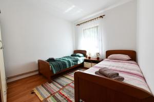 a bedroom with two beds and a window at Holiday house with a parking space Saborsko, Plitvice - 23935 in Saborsko