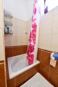 a bathroom with a tub with pink flowers in a shower curtain at Holiday house with a parking space Saborsko, Plitvice - 23935 in Saborsko